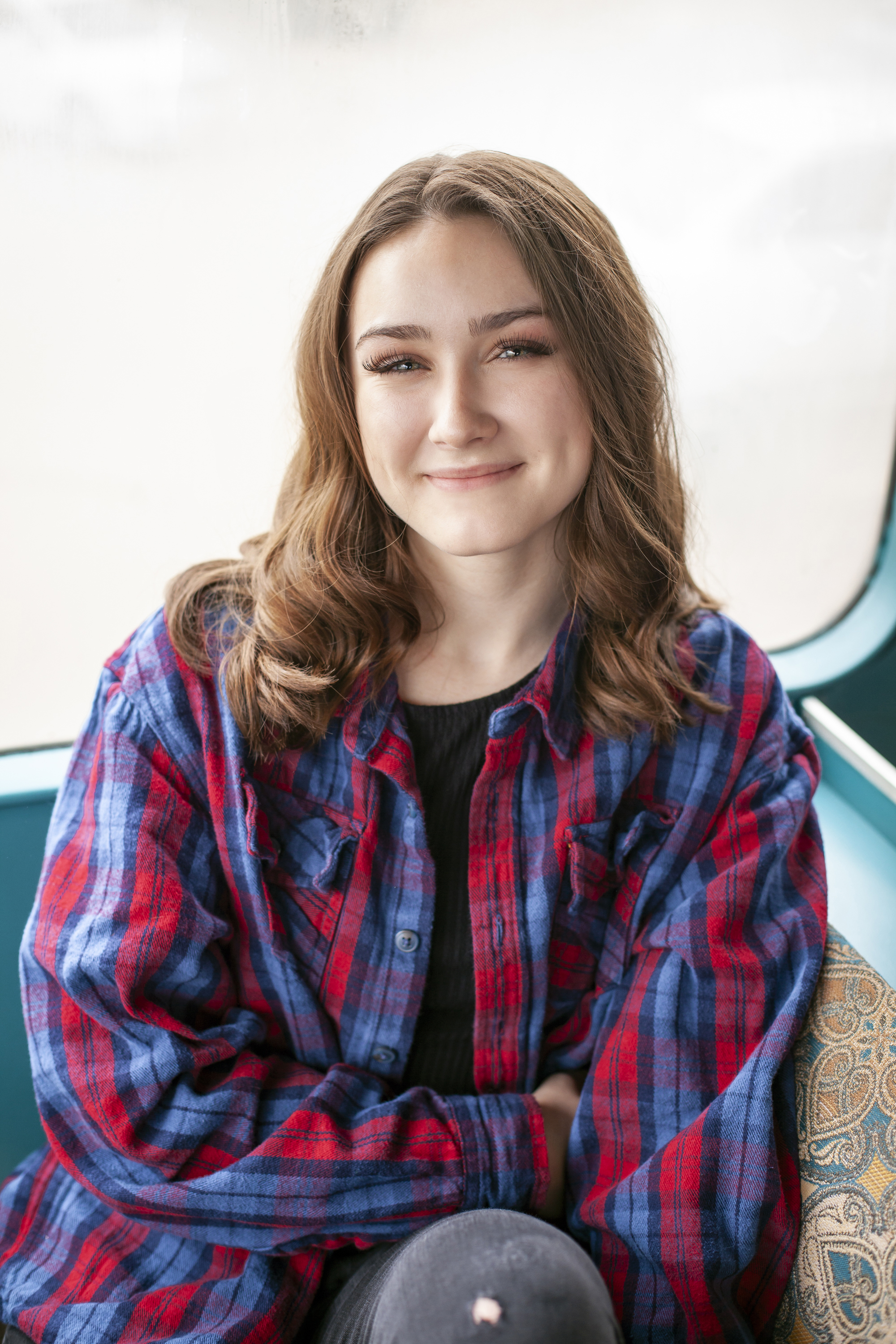 headshot of a brunette hair girl in a flannel top