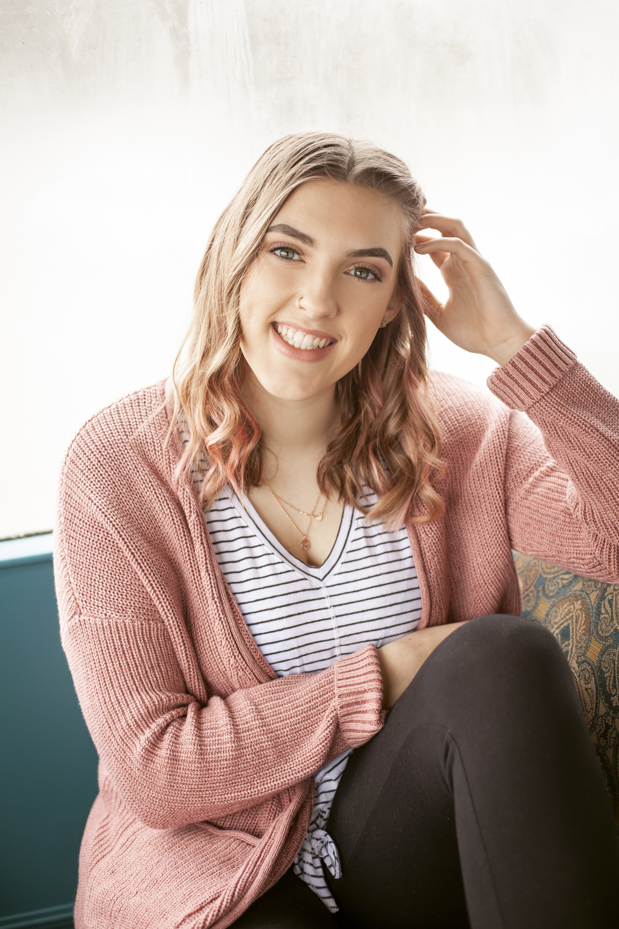 senior portrait of a girl with pink hair and pink caridgan 