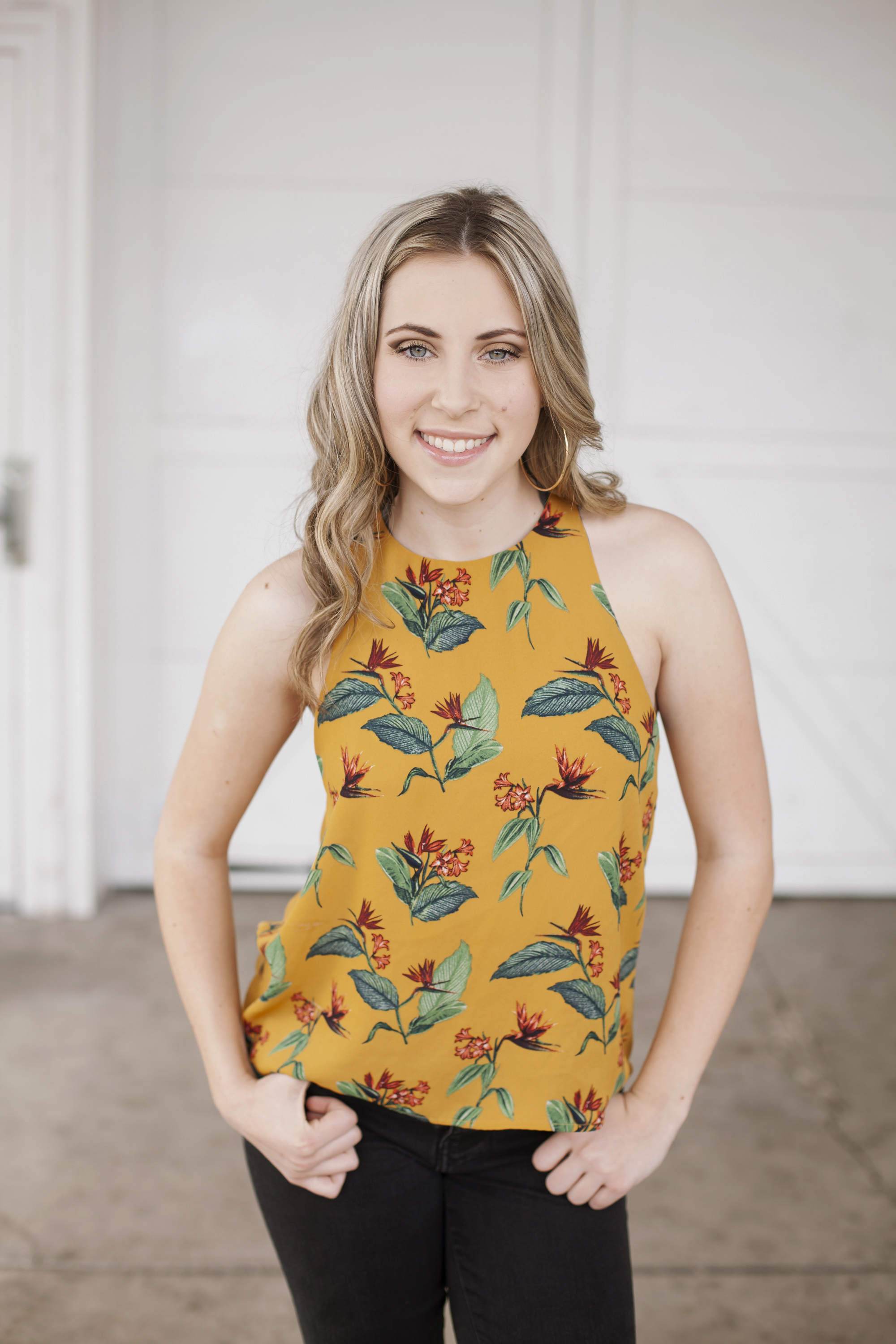 portrait of blonde girl in yellow spring top in urban setting