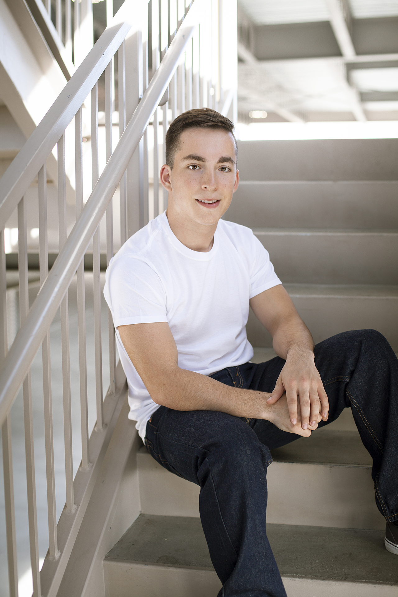 senior guy sitting on stairs in white t shirt